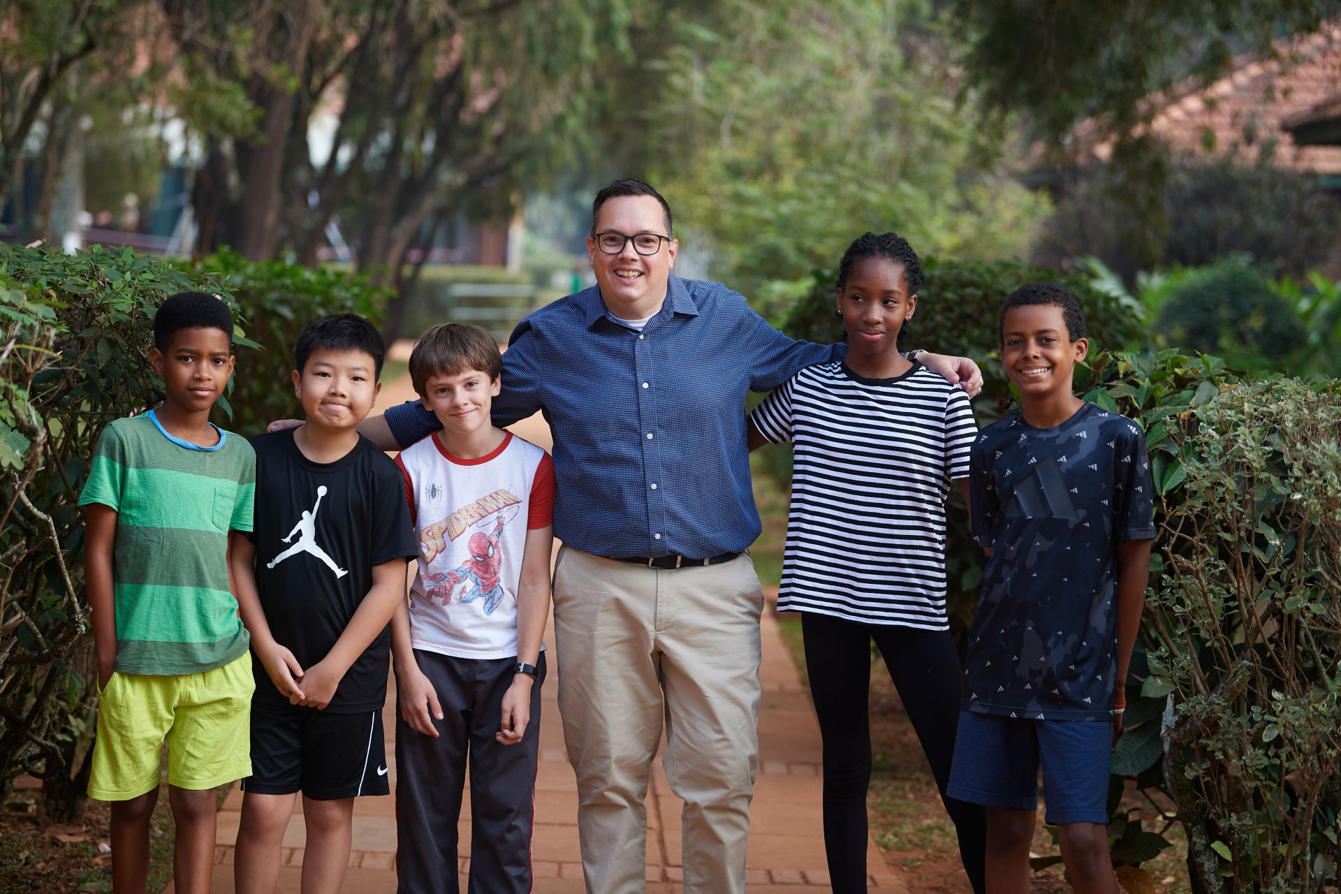 A man stands with several children, creating an atmosphere of joy and interaction among them.