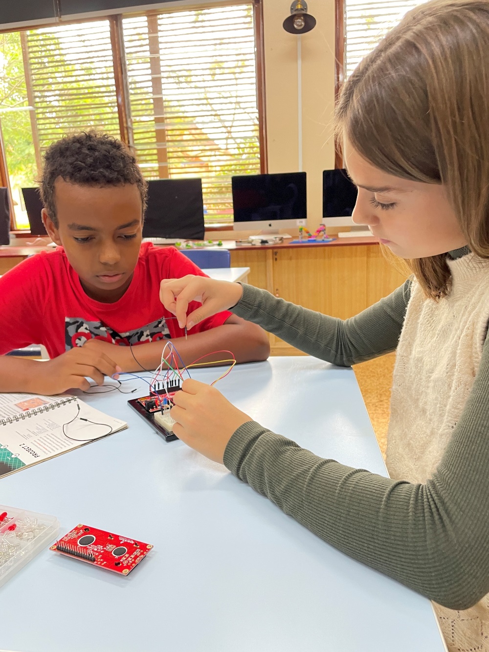 two students in the classroom, engaged in experiements