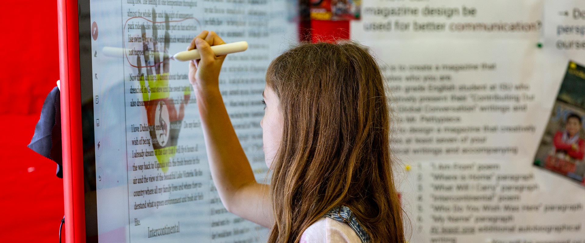 Girl writing on an interactive whiteboard at the International School of Uganda