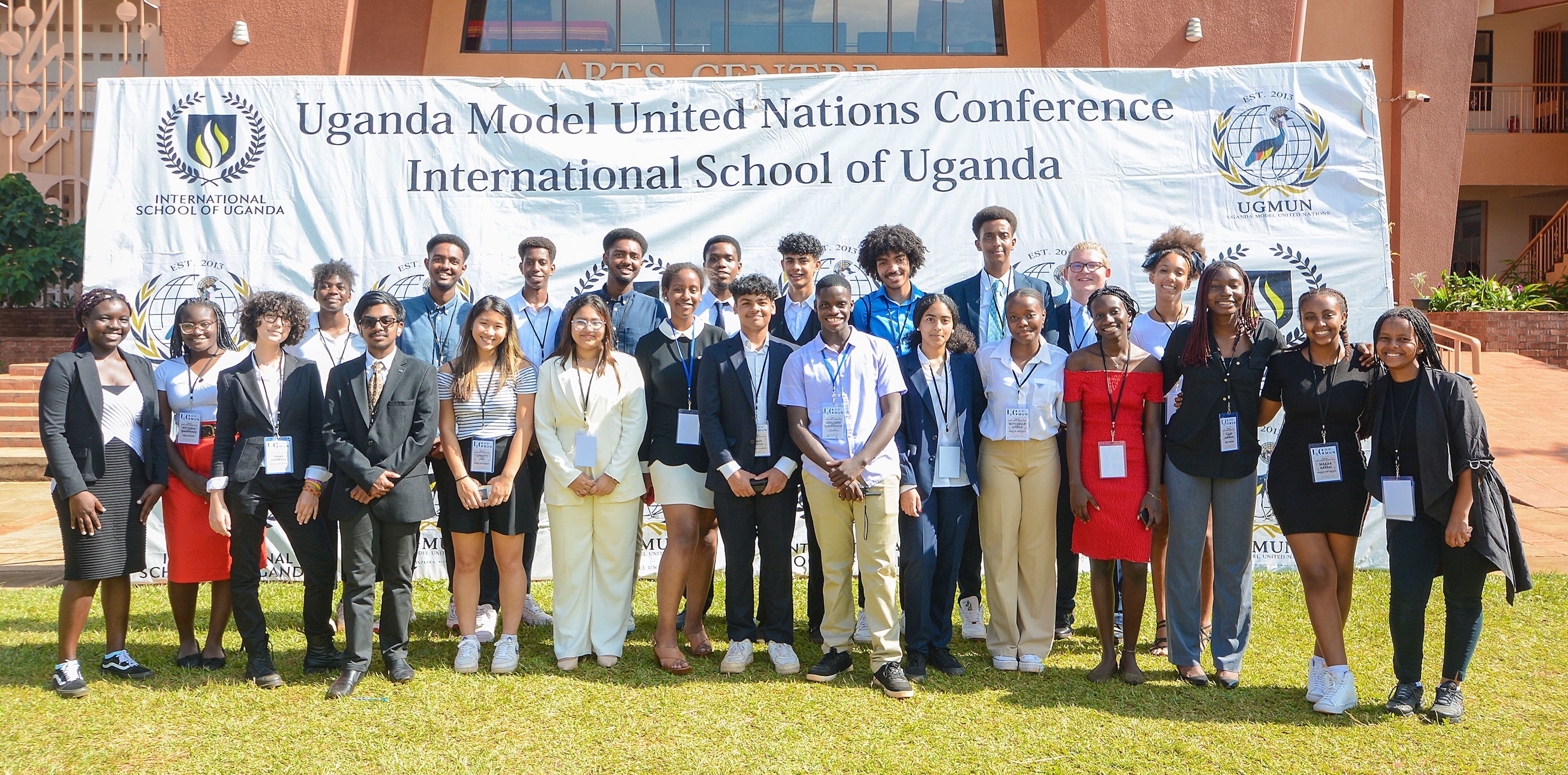 Students and teachers standing in front of a banner that reads 'Uganda Model United Nations Conference International School of Uganda'