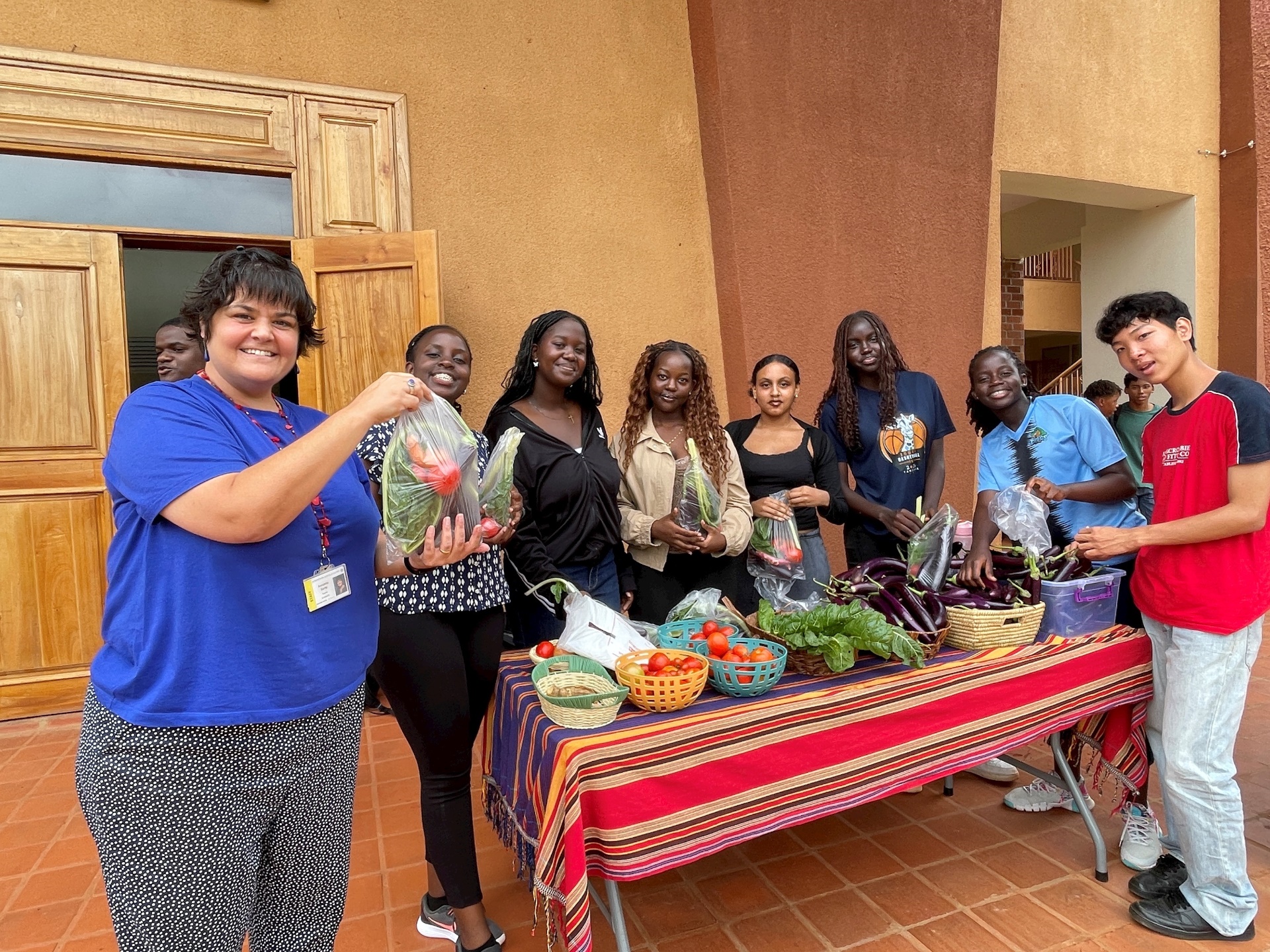 students around a table filled with fresh vegetables