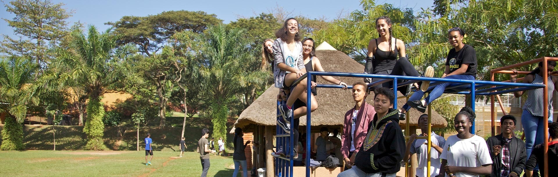 ISU alumni smiling and playing on a climbing frame